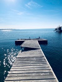 Damaged pier over sea against blue sky