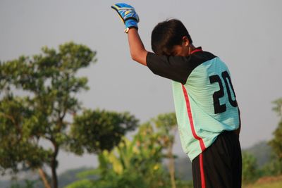 Man in sports clothing standing against sky