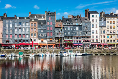 Sailboats in canal against buildings in city