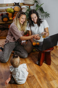 Smiling young woman sitting on wooden table at home