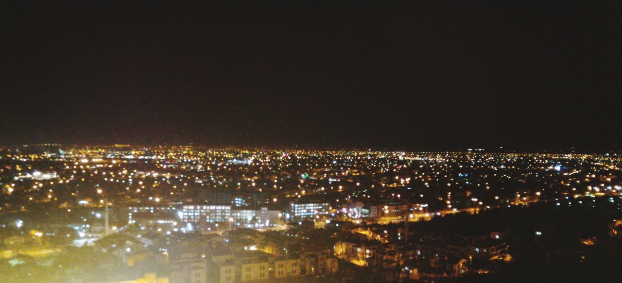 illuminated, city, cityscape, night, architecture, built structure, copy space, high angle view, building exterior, crowded, clear sky, light, dark, water, city life, sky, aerial view, wide, development, outdoors, wide shot, residential district, no people, capital cities, scenics, darkness, modern