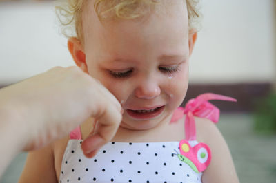 Close-up of crying baby girl at home