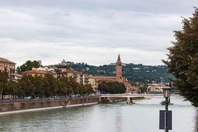 Arch bridge over river against buildings in city