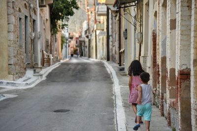 Rear view of children walking on street