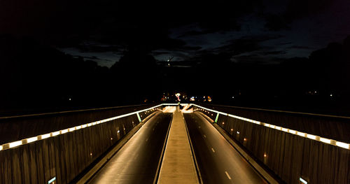 Illuminated suspension bridge against sky at night