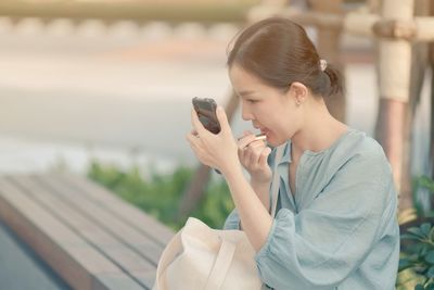 Young woman using mobile phone outdoors