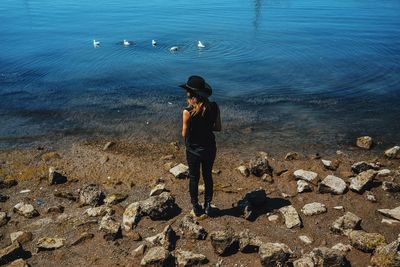 Rear view of woman standing on shore at beach