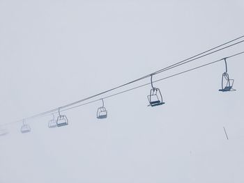 Low angle view of overhead cable car against sky