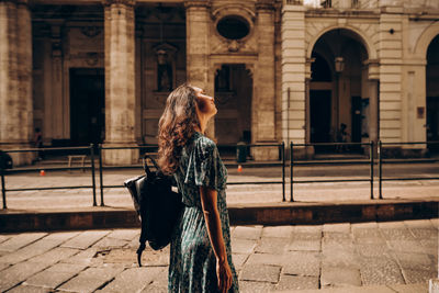 A beautiful woman walks with backpack in turin, italy