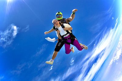 Low angle view of man jumping against sky