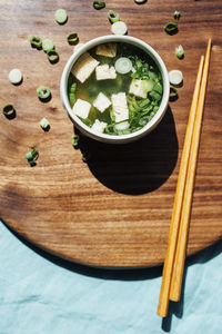 High angle view of soup bowl with chopsticks on serving board in commercial kitchen