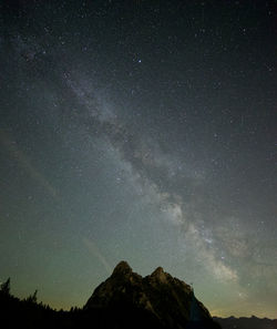 Low angle view of silhouette mountain against sky at night