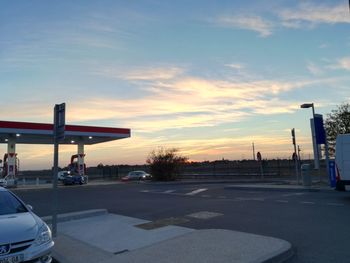 View of city street against sky during sunset