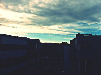 Low angle view of buildings against cloudy sky