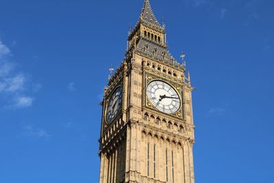 Low angle view of clock tower against blue sky big ben