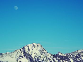 Scenic view of snowcapped mountains against clear blue sky