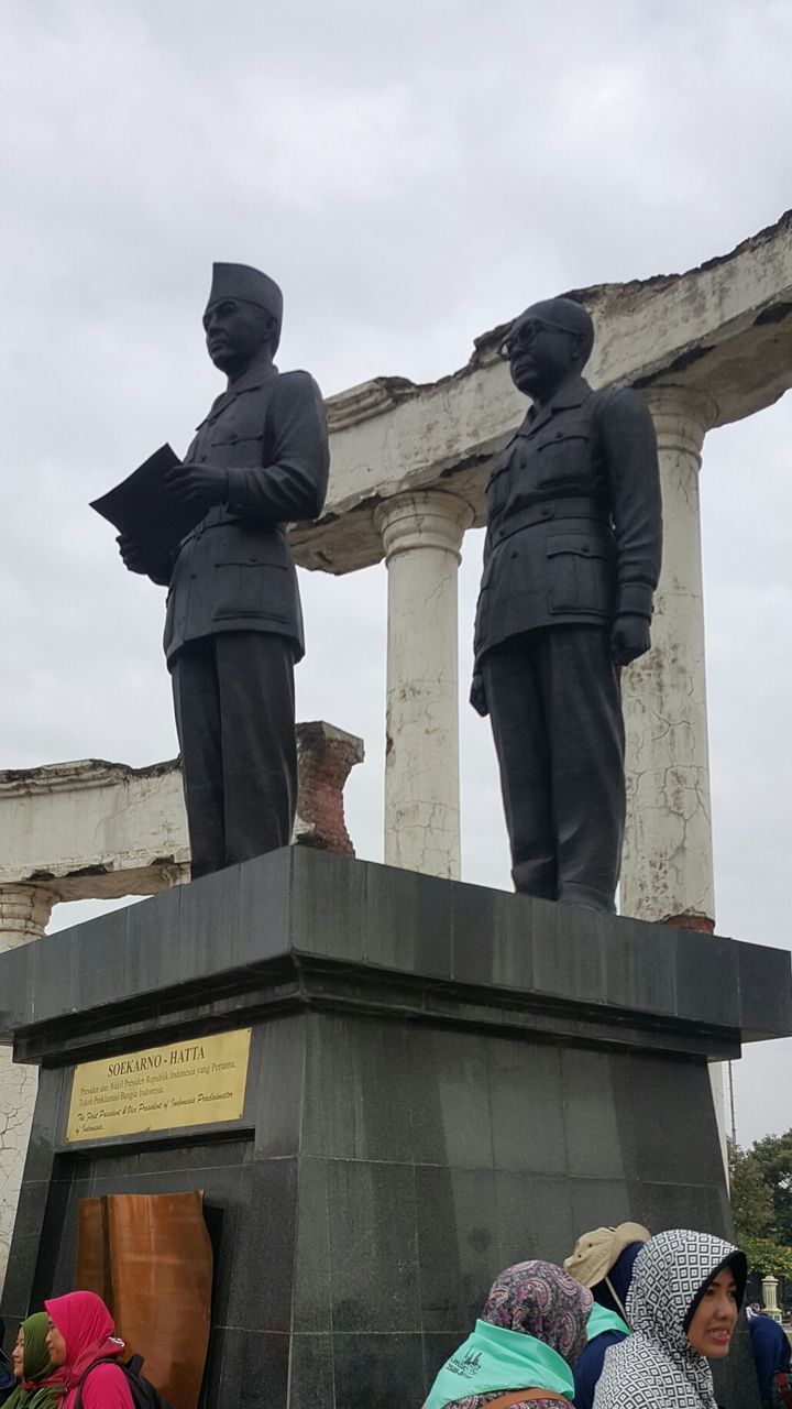 human representation, male likeness, real people, low angle view, sculpture, day, sky, men, statue, built structure, outdoors, lifestyles, architecture, building exterior, people