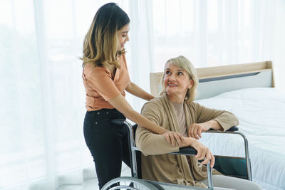 Smiling woman sitting on window in office