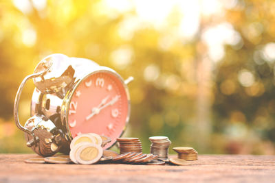 Alarm clock with coins on table