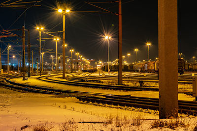 Illuminated railroad station platform at night