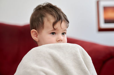 Portrait of a cute young boy watching tv whith his safety blanket