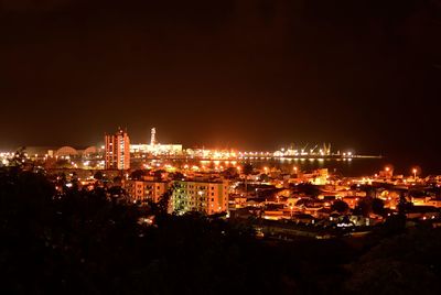 Illuminated cityscape against sky at night