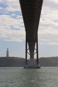 View of bridge over sea against cloudy sky