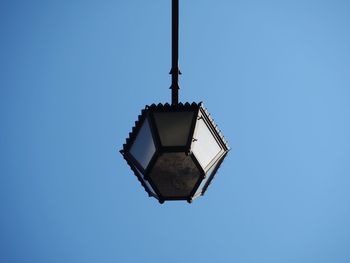 Low angle view of illuminated lamp against clear blue sky