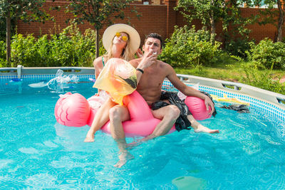 Full length of friends enjoying in swimming pool