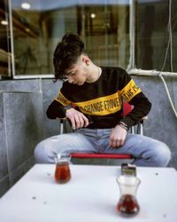 Full length of man sitting in glass window