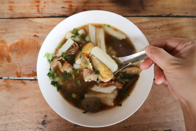 Cropped image of person having food in bowl