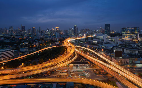 High angle view of light trails on road amidst buildings in city