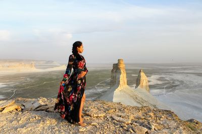 Young woman looking at sea shore against sky