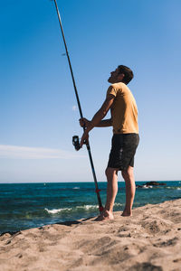 Full length of man fishing on beach