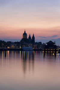 Reflection of buildings in city at sunset