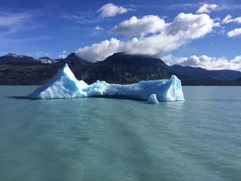 Scenic view of icebergs in sea against sky