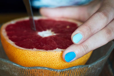 Close-up of hand holding grapefruit