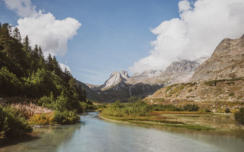 Scenic view of lake by mountains against sky