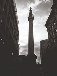 Low angle view of buildings against cloudy sky