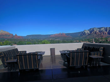 Chairs and tables against clear blue sky