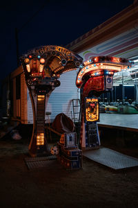 Illuminated carousel in amusement park at night