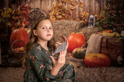 Portrait of young woman holding pumpkin