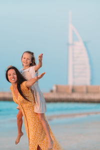 Portrait of woman standing by sea against sky