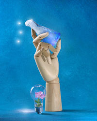 Man holding bottle against blue background