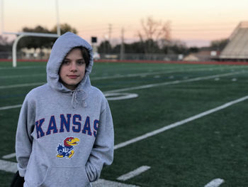 Portrait of boy standing on football field on a cold day 