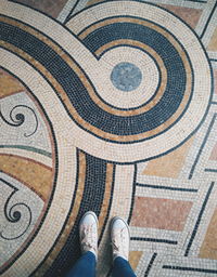 Low section of man standing on tiled floor