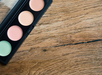 Directly above shot of multi colored eyeshadow palette on wooden table