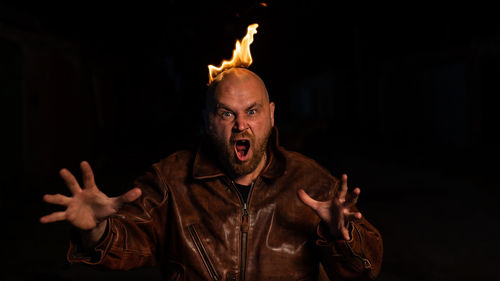 Portrait of man against black background