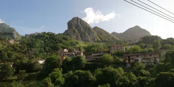 Panoramic shot of buildings and mountains against sky