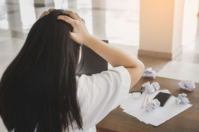 Midsection of woman with text on white table